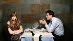 Mann und Frau sitzen am Tisch und haben Streit